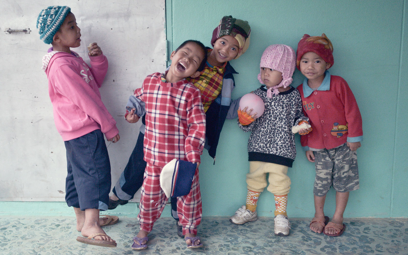 Photography of street kids posing and smiling, dressed in colourful mix-and-match clothes.