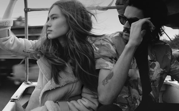 Campaign image of a man and woman wearing our latest collection sitting in the back of a moving pick-up truck.