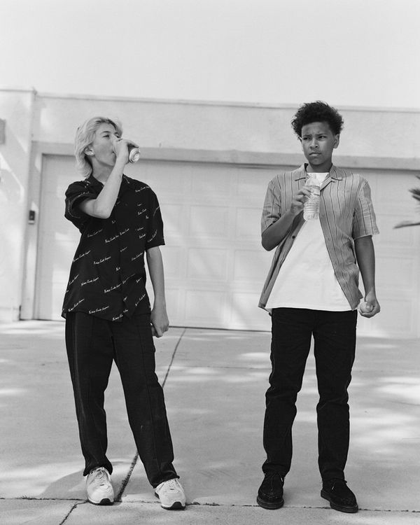 Black and white image of two young men standing in the street and wearing pieces from the latest capsule collection