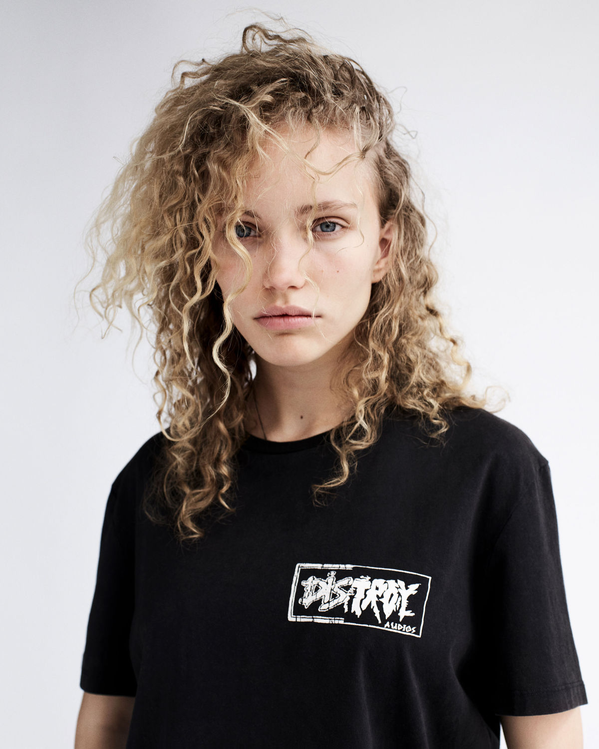 Portrait of a young woman wearing a black graphic t-shirt from our latest collection.