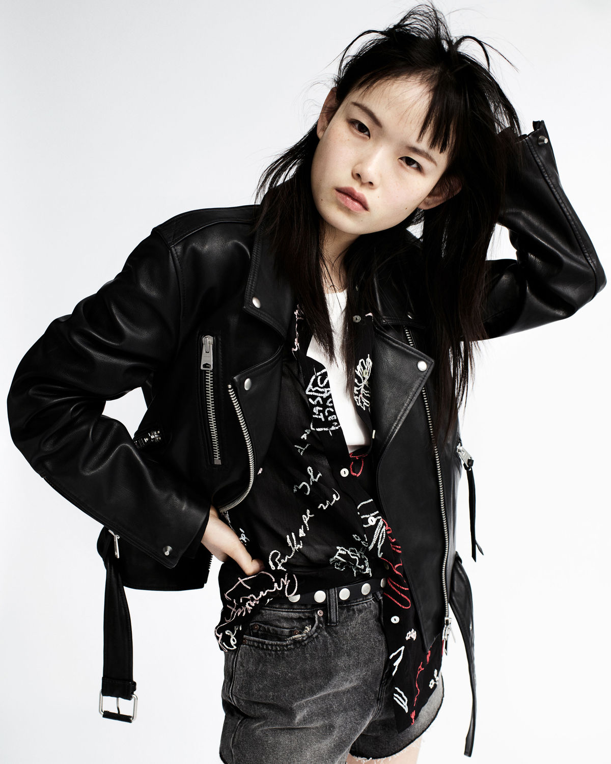 Photograph from our new Biker Portraits series, featuring a young woman wearing high waisted denim shorts and a graphic shirt, complete with an oversized leather biker.