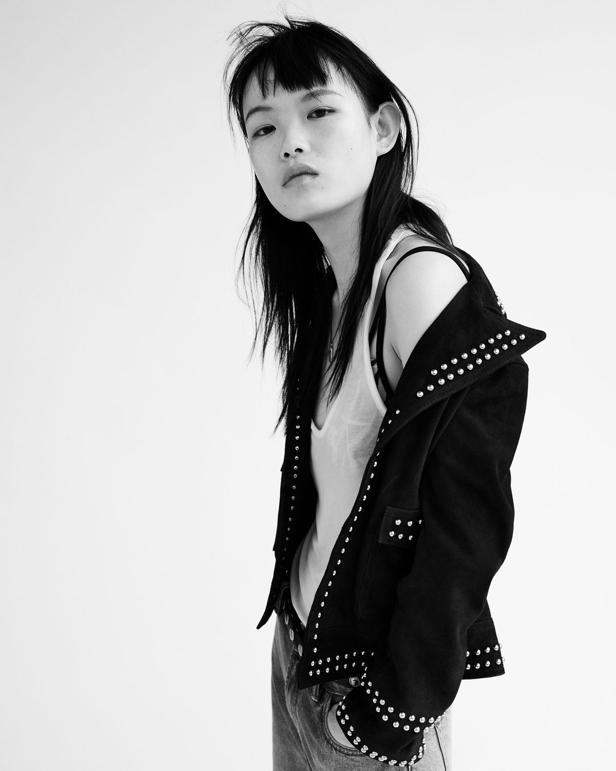Black and white photograph from our new Biker Portraits series, featuring a young woman wearing high waisted denim shorts and a studded jacket from our latest collection.