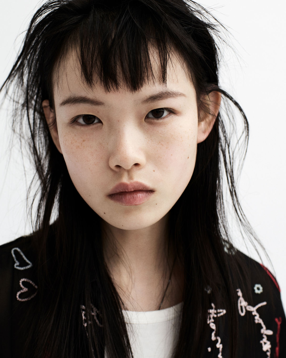 Close-up portrait of a young woman from our new Biker Portraits series, wearing a graphic shirt from our latest collection.