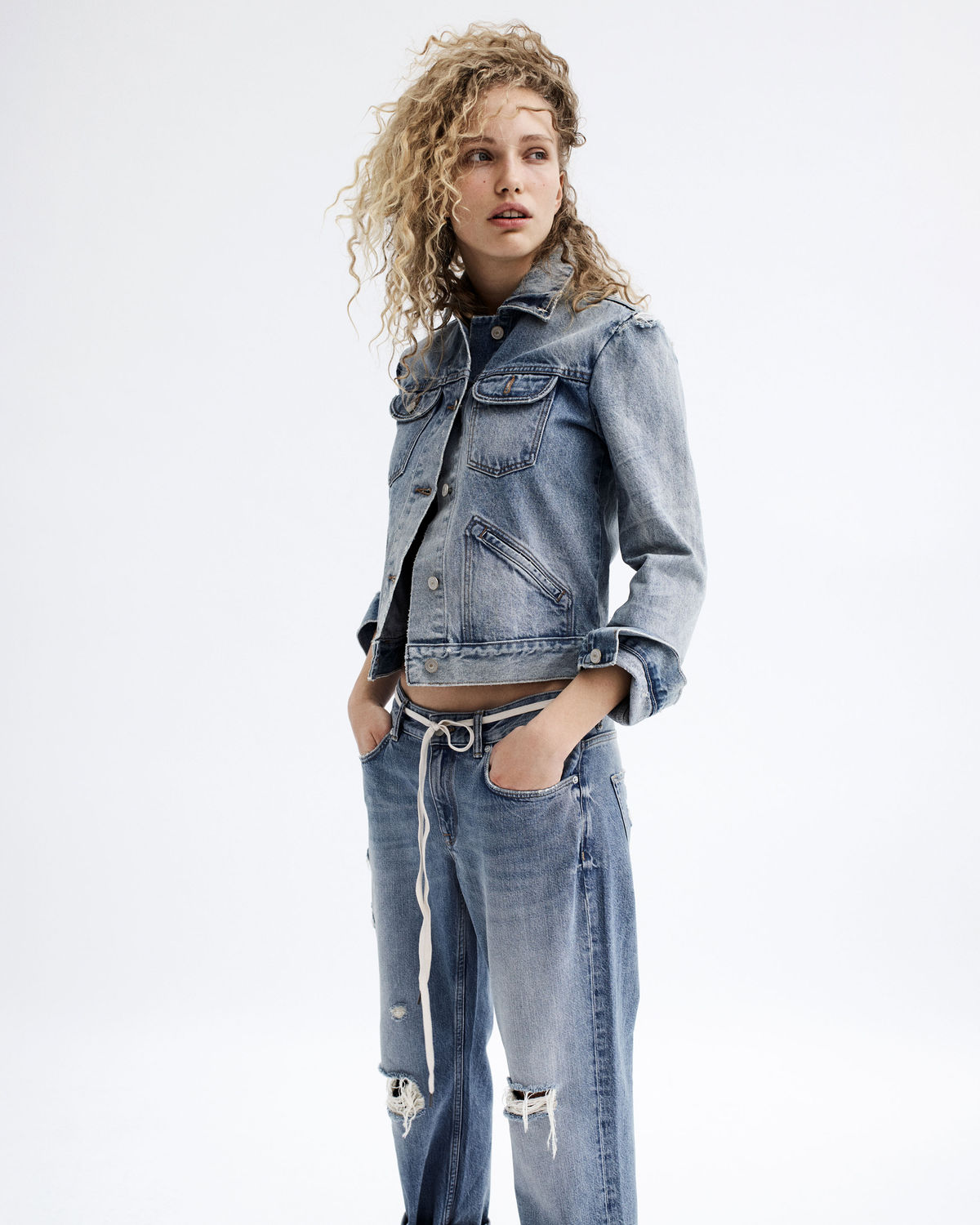 Portrait of a young woman wearing a denim jacket and boyfriend fit jeans from our latest collection.