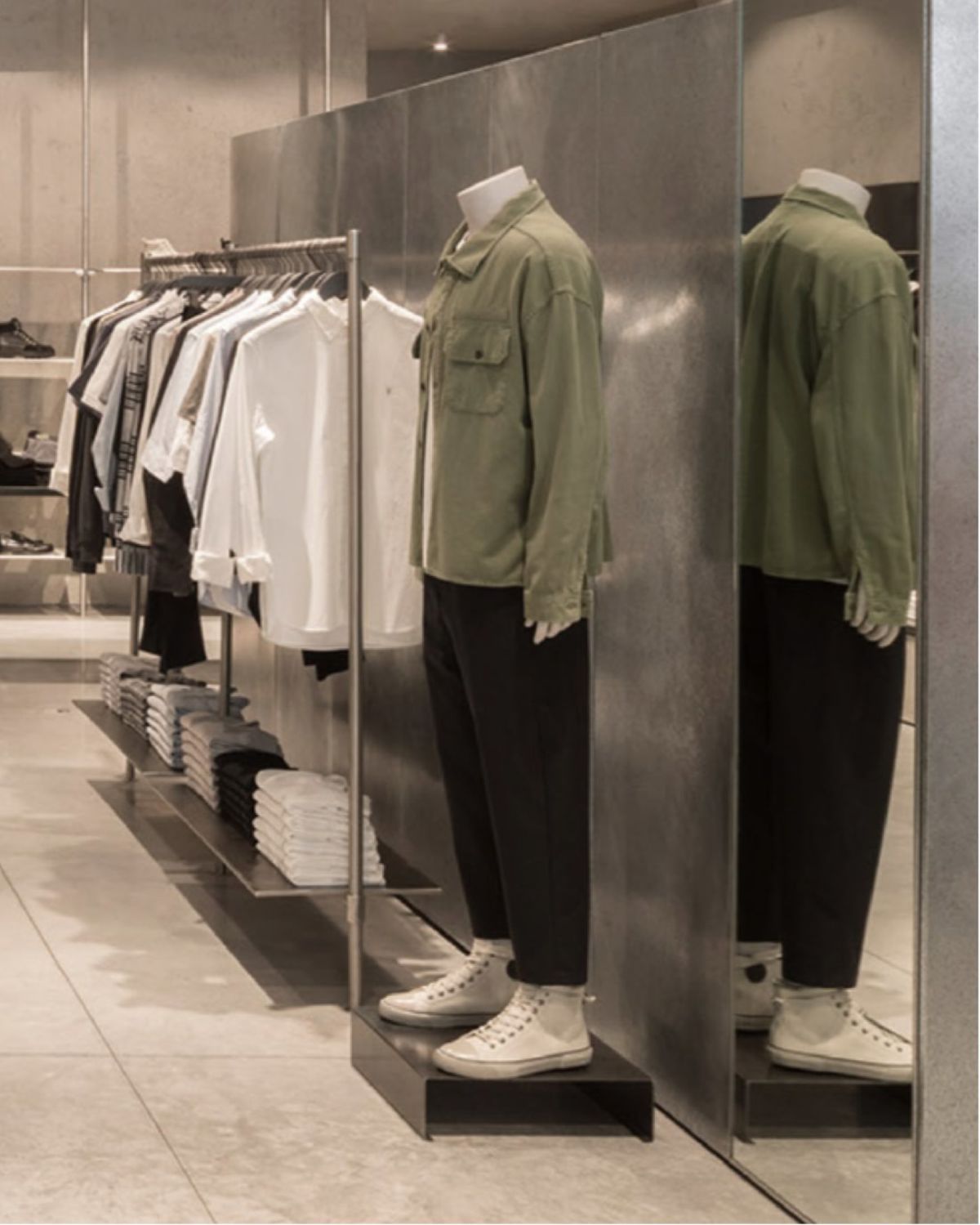Mannequin in store near items from the men's collection.