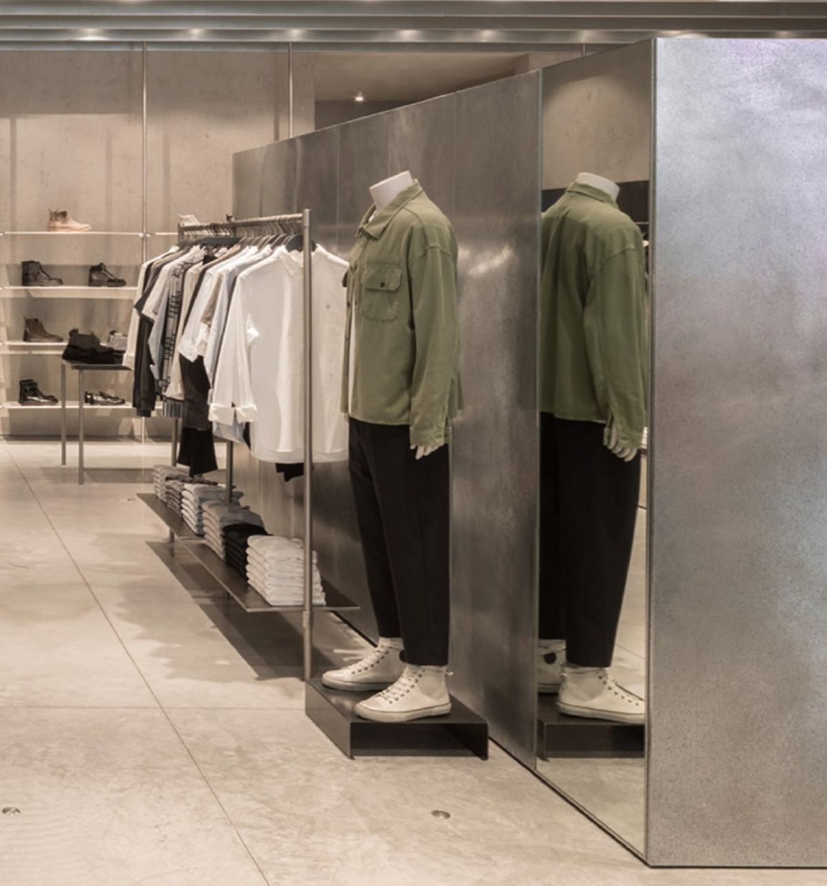 Mannequin in store near items from the men's collection.