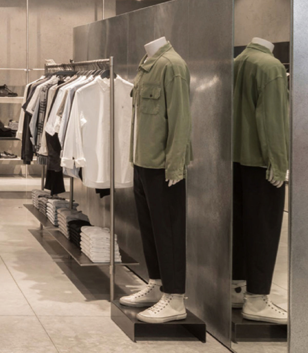 Mannequin in store near items from the men's collection.