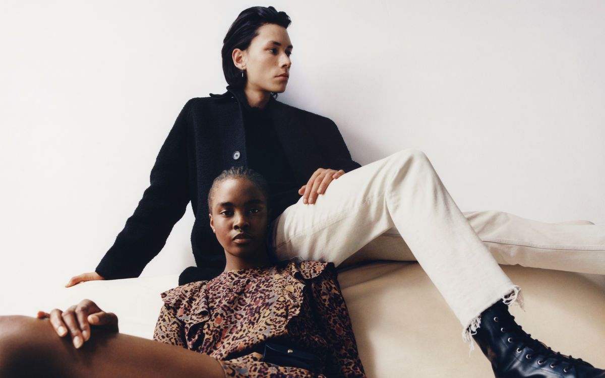 Woman and a man sitting on a couch wearing items from our latest collection.