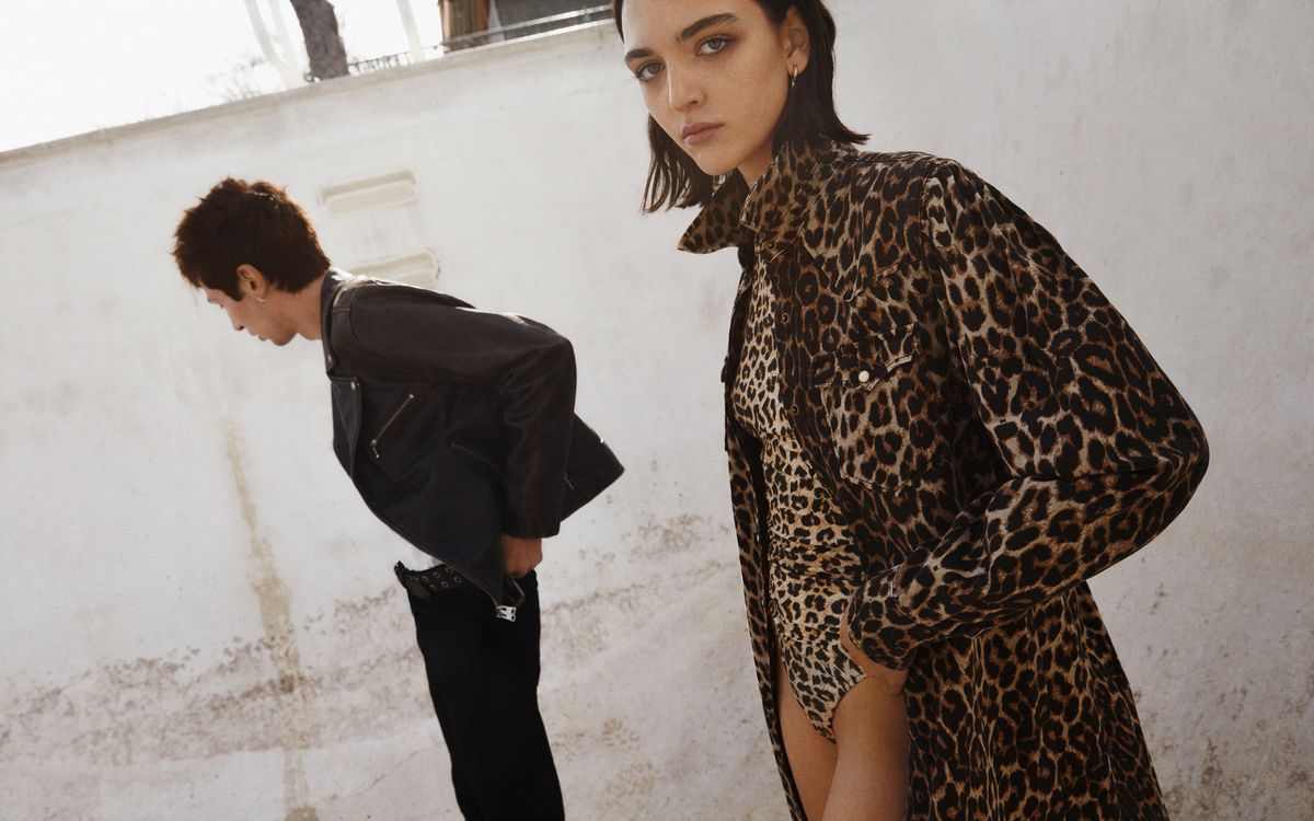 Woman and a man standing in a street wearing items from our latest collection.