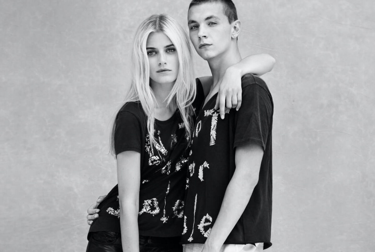 Black and white portrait of a man and a woman wearing T-shirts from the Not For Sale Capsule collection.