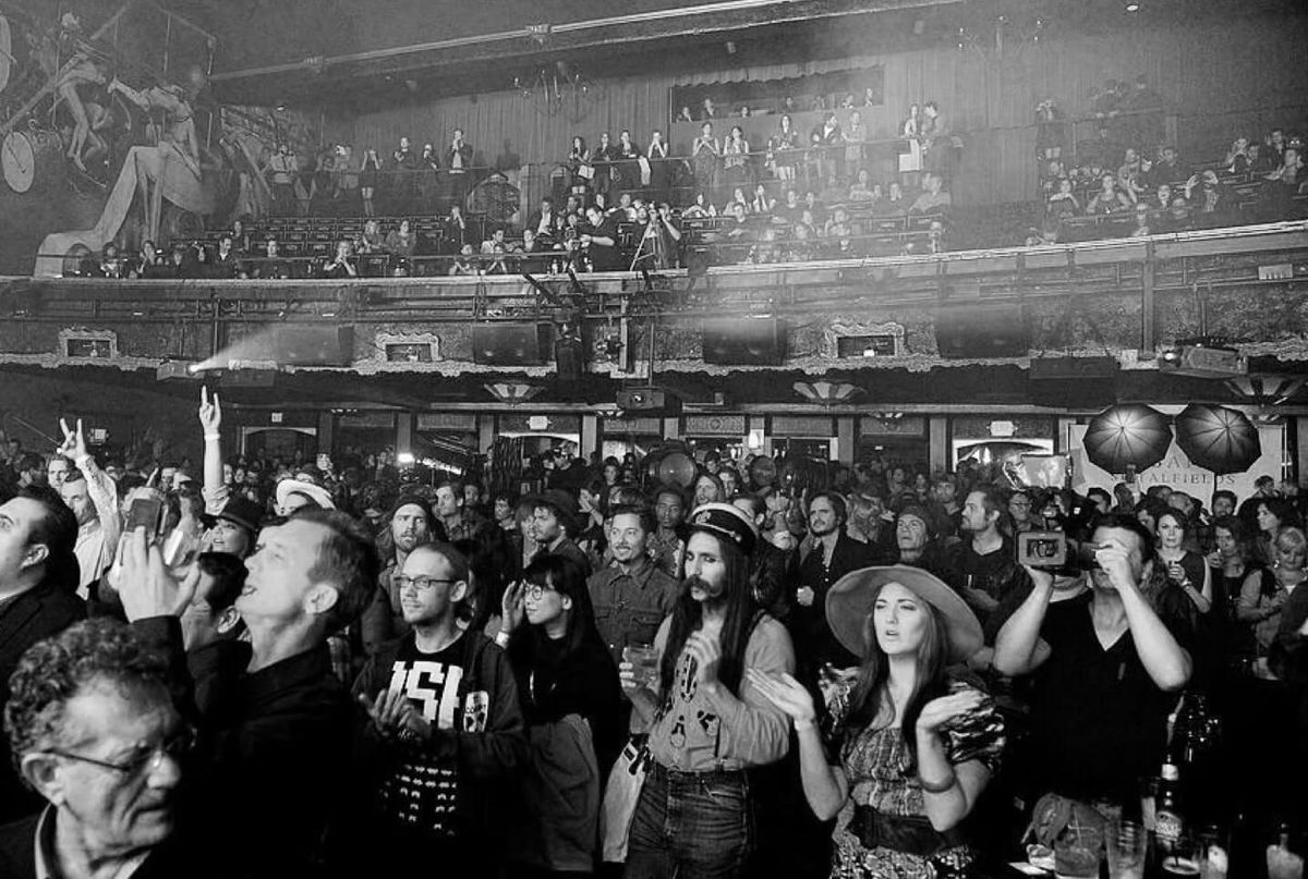 Schwarz-Weiß-Bild einer Menschenmenge in einem Theater.