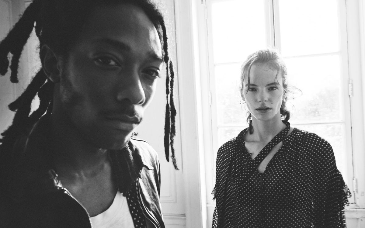Man and a woman looking straight at the camera and wearing items from our latest collection.