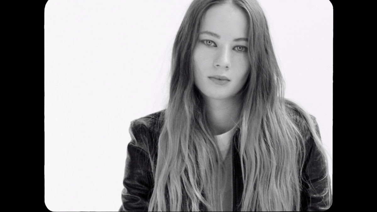 Video placeholder. Black and white portrait of a woman wearing a leather jacket.