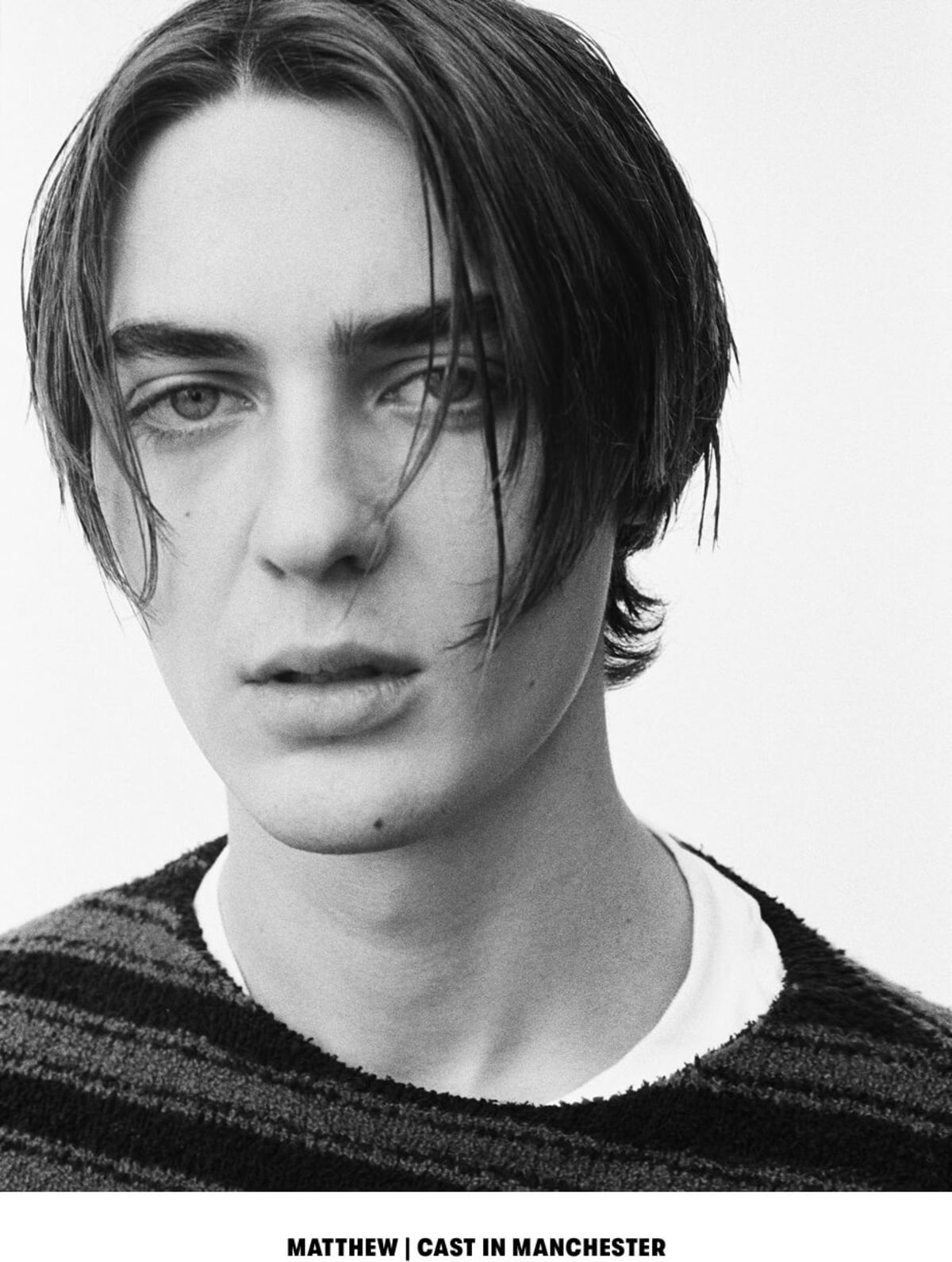 MATTHEW | CAST IN MANCHESTER. Black and white close up portrait of a man wearing a striped sweater over a white t-shirt.