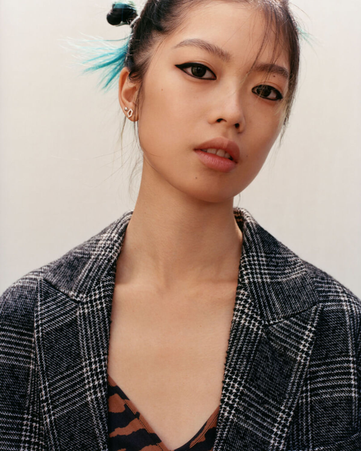 Portrait of a woman wearing a checked coat over an orange zebra printed dress.