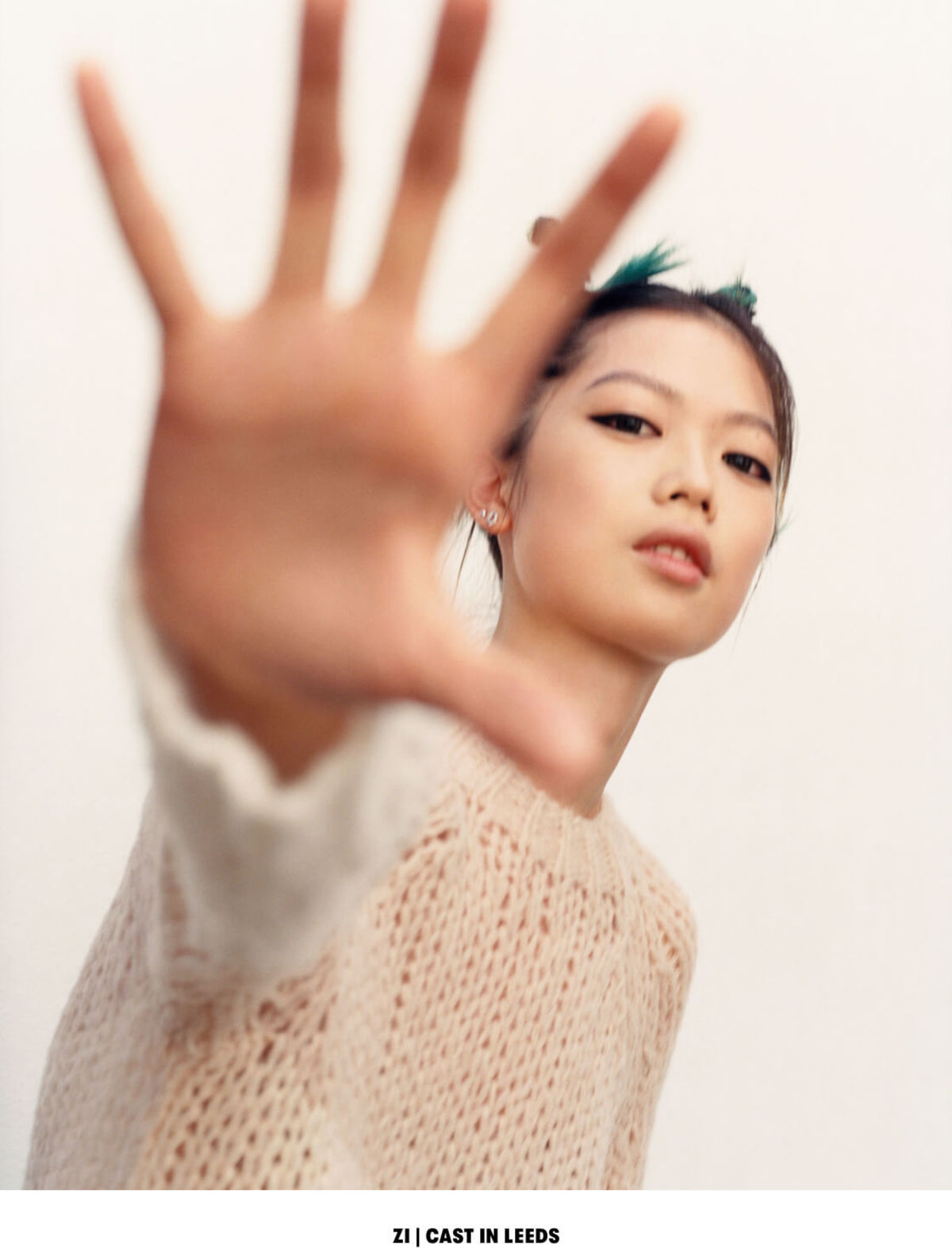 ZI | CAST IN LEEDS. Portrait of a woman wearing a cream coloured sweater.