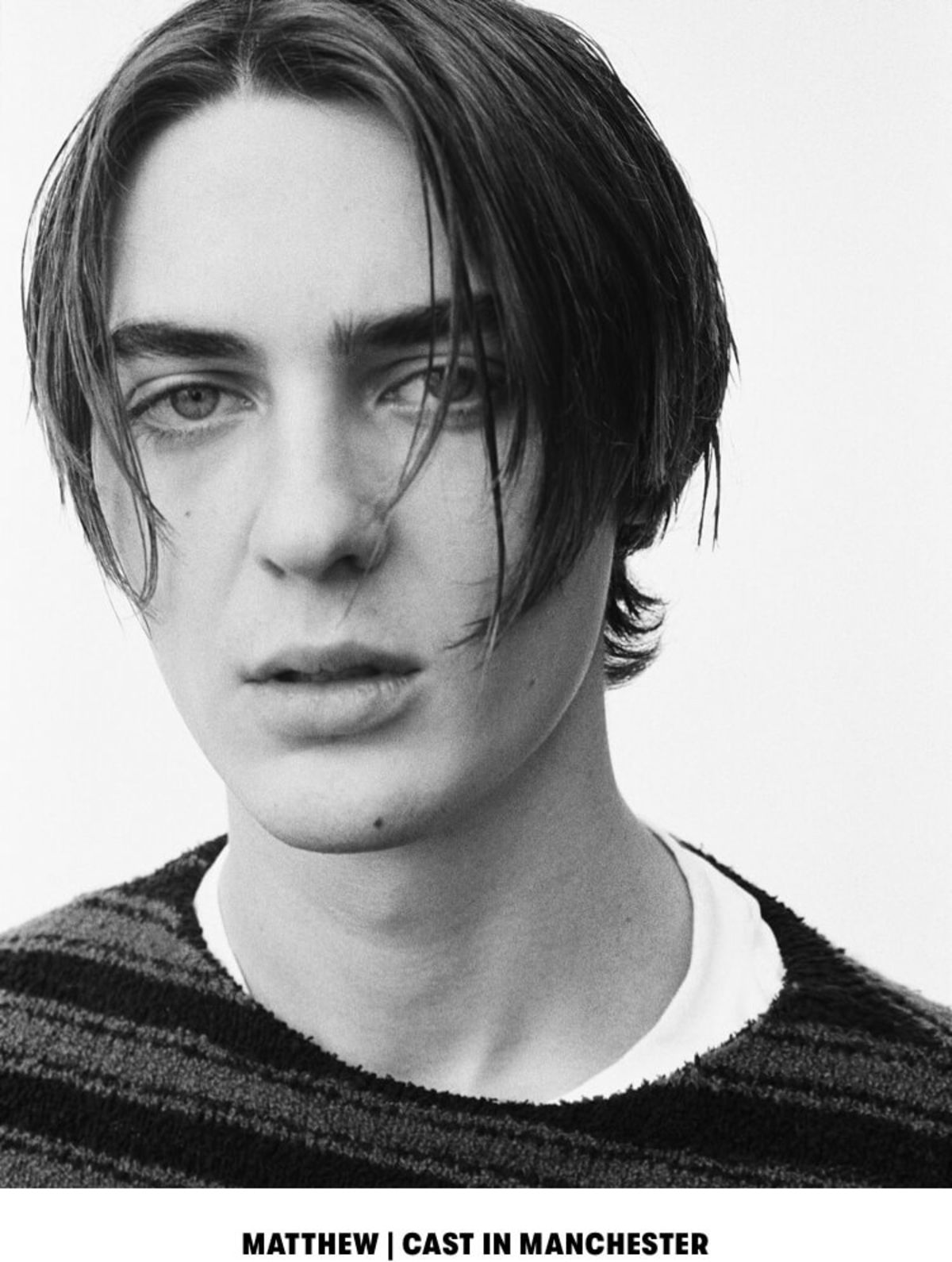 MATTHEW | CAST IN MANCHESTER. Black and white close up portrait of a man wearing a striped sweater over a white t-shirt.