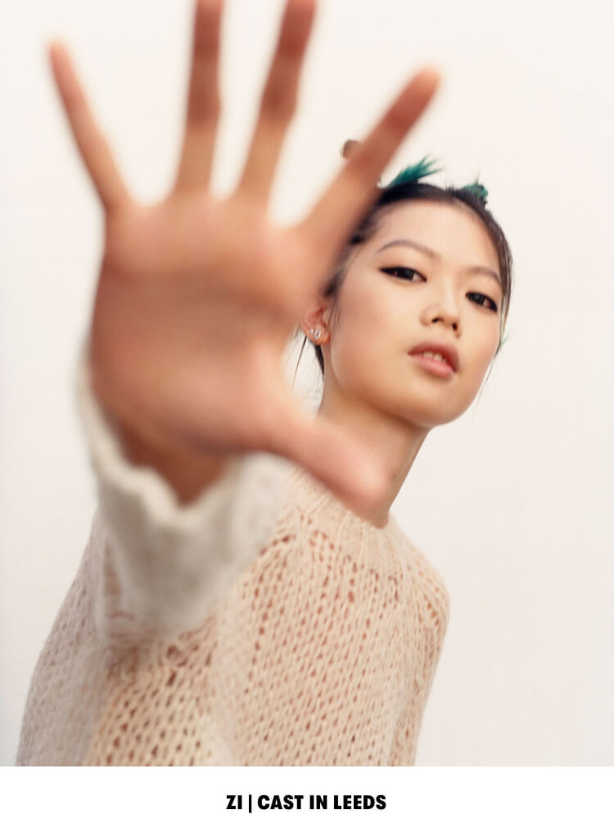 ZI | CAST IN LEEDS. Portrait of a woman wearing a cream coloured sweater.