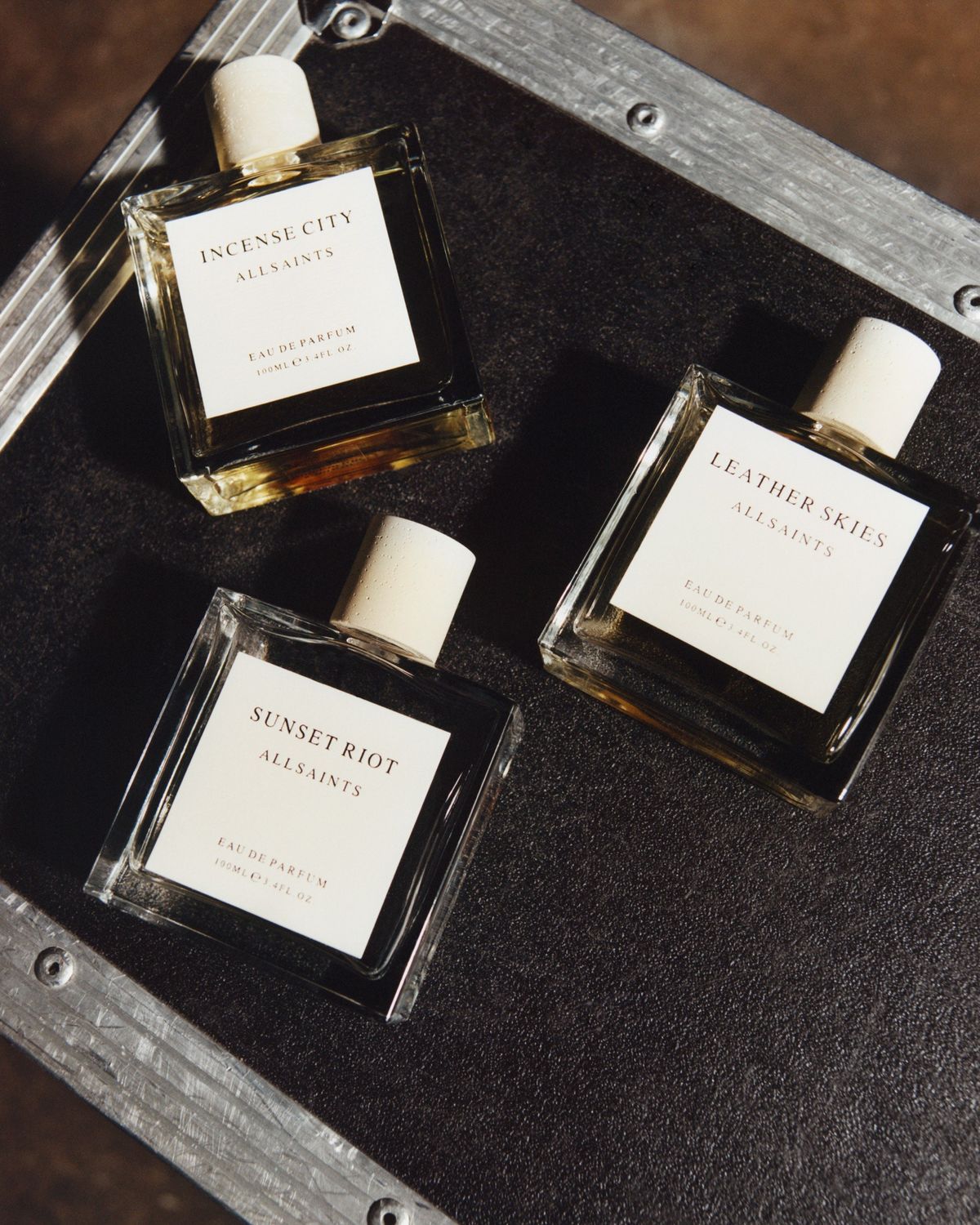 Image of three of our fragrance in front of a red background.