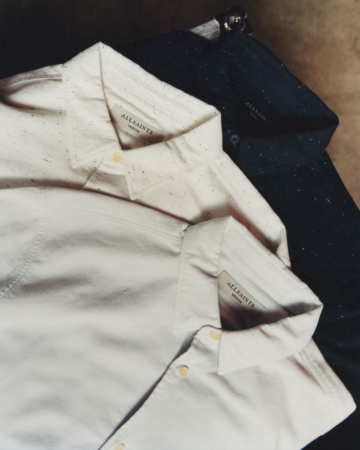 Close up of three shirts piled up.