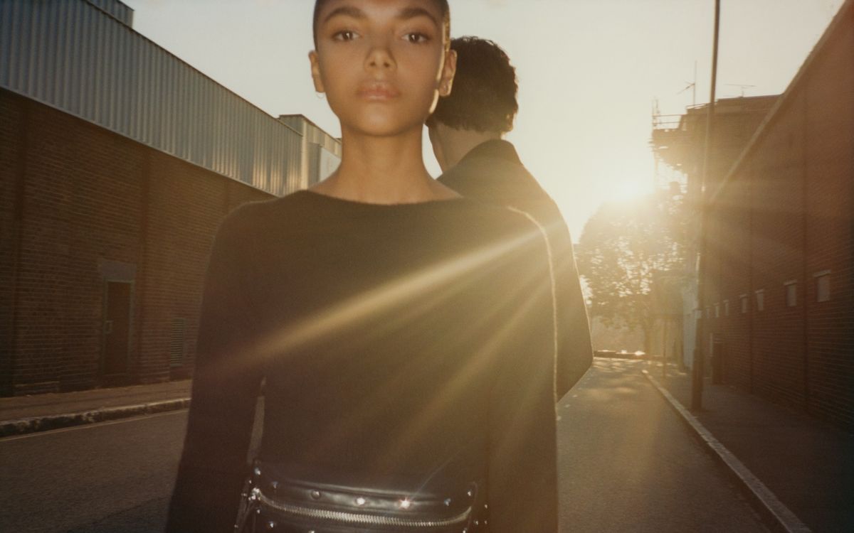 Image of a woman and a man in the street at sunset.