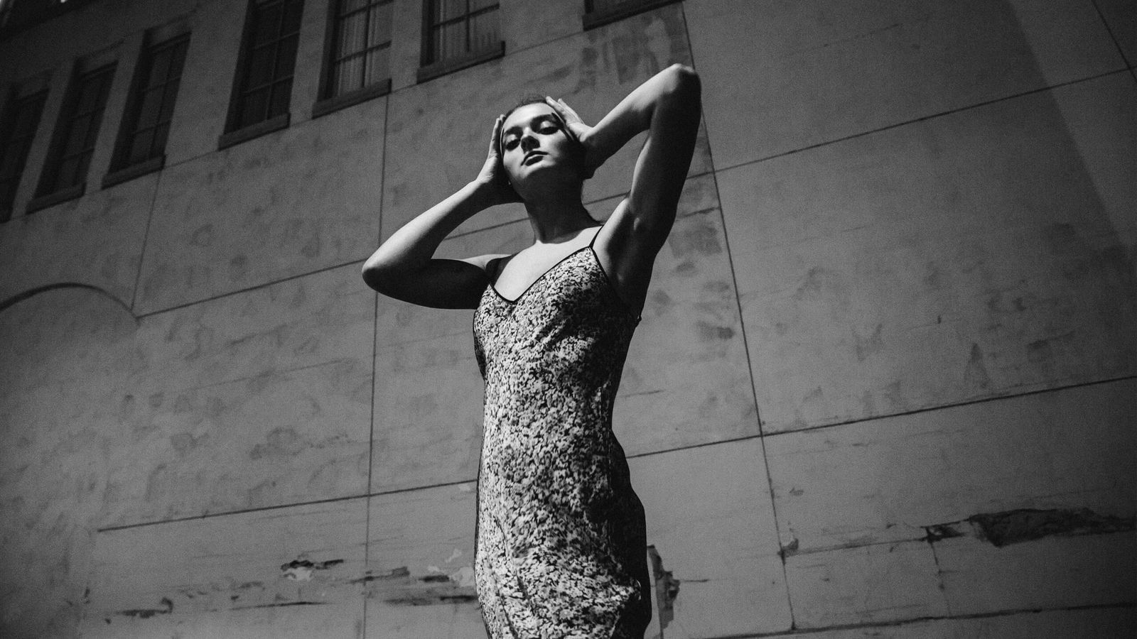 Black and white images of Charlotte Lawrence in the street wearing a thin strap flower printed dress.