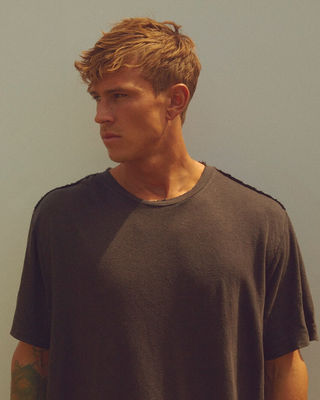 Ritratto di un uomo che indossa una t-shirt nera oversize.