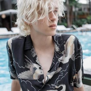 Close up portrait of a man wearing a dark printed Hawaiian shirt.