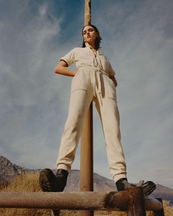 Woman wearing a white jumpsuit.