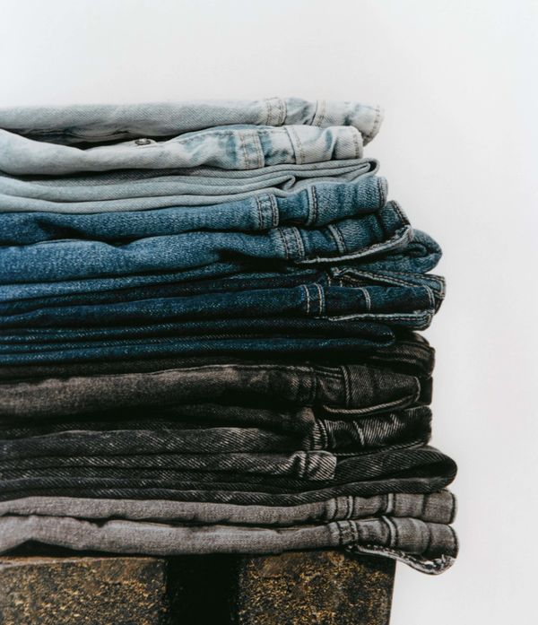 Pile of jeans on a table.