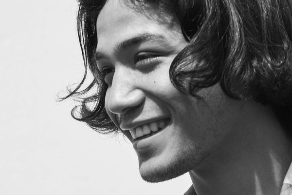 Black and white portrait of a young man smiling.
