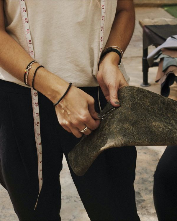 A woman is checking the zip on a sleeve of one of our leather jacket.