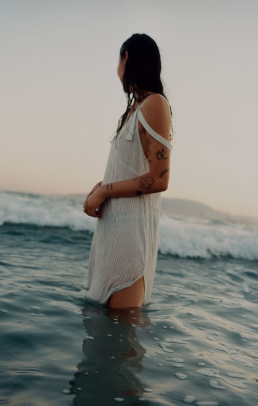 Image of a woman in the sea wearing a white dress.