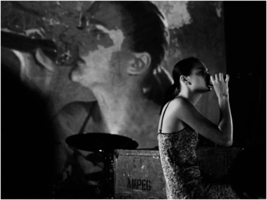 Black and white image of Charlotte Lawrence singing on stage.