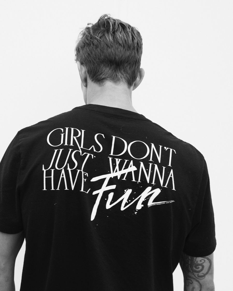 Image en noir et blanc d'un homme portant notre t-shirt noir créé pour la journée internationale de la femme.
