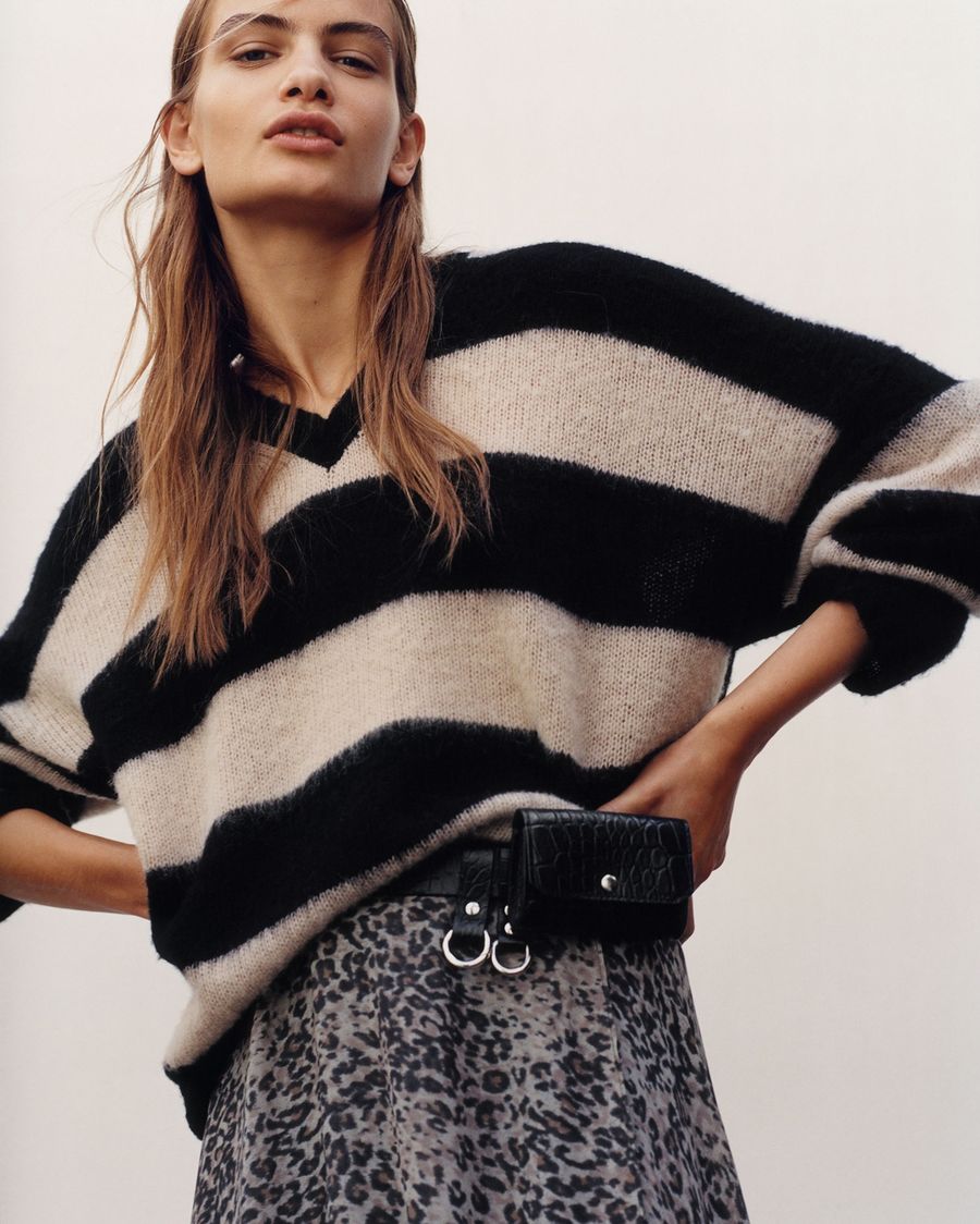 Cropped image of a woman wearing a striped jumper with leopard printed skirt.