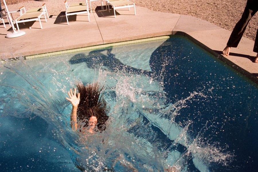 Image of a woman jumping in a pool.