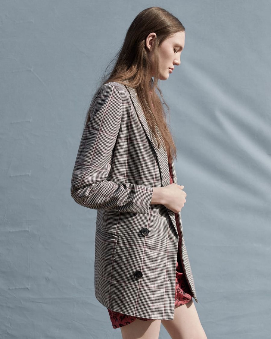 Image of a woman wearing a checked tailored jacket.