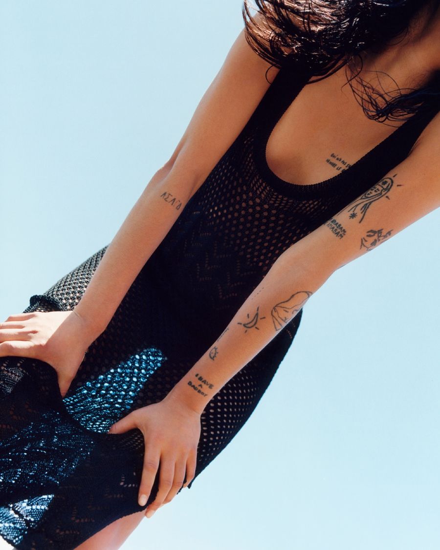 Imagen en contrapicado de una mujer con un vestido negro en crochet.