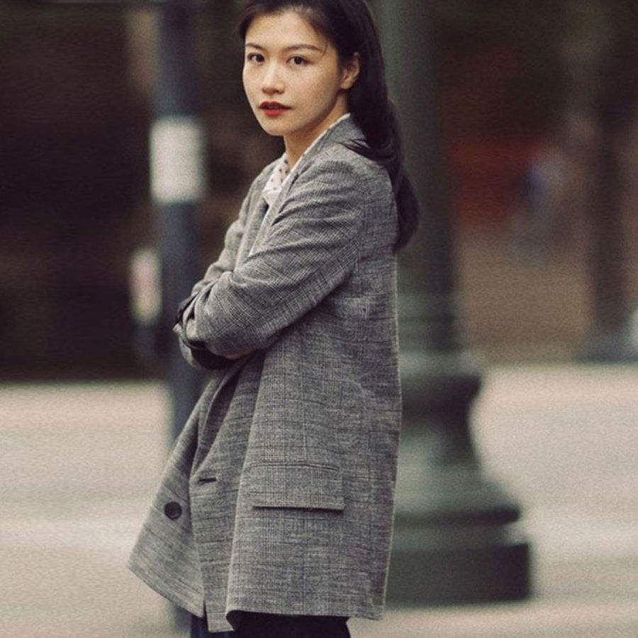 Image of a woman sitting in a street wearing a leather jacket.