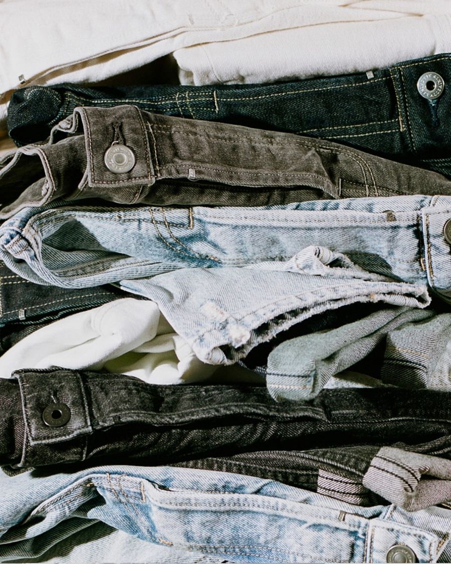 Inquadratura su una pila di jeans di colori diversi.