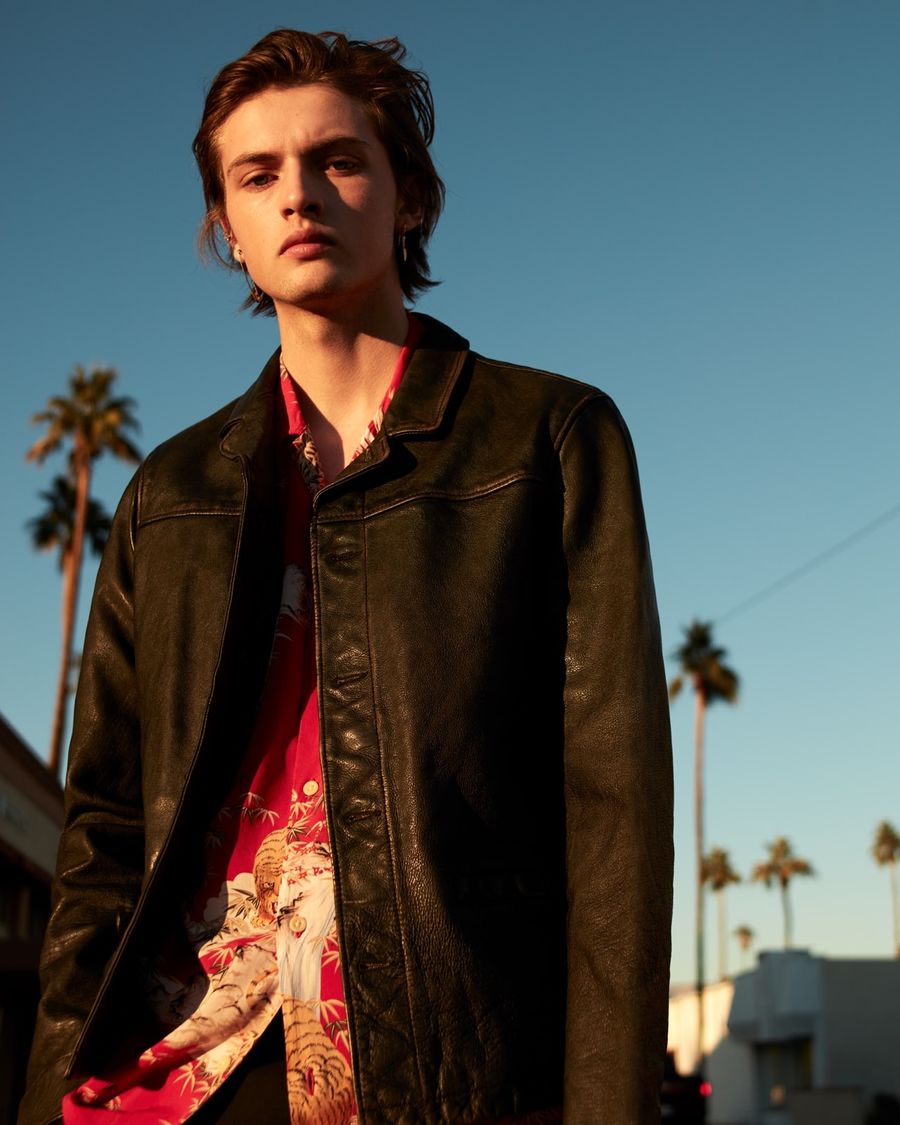 Portrait of a man wearing a red Japanese-inspired printed Hawaiian shirt under a black leather jacket.