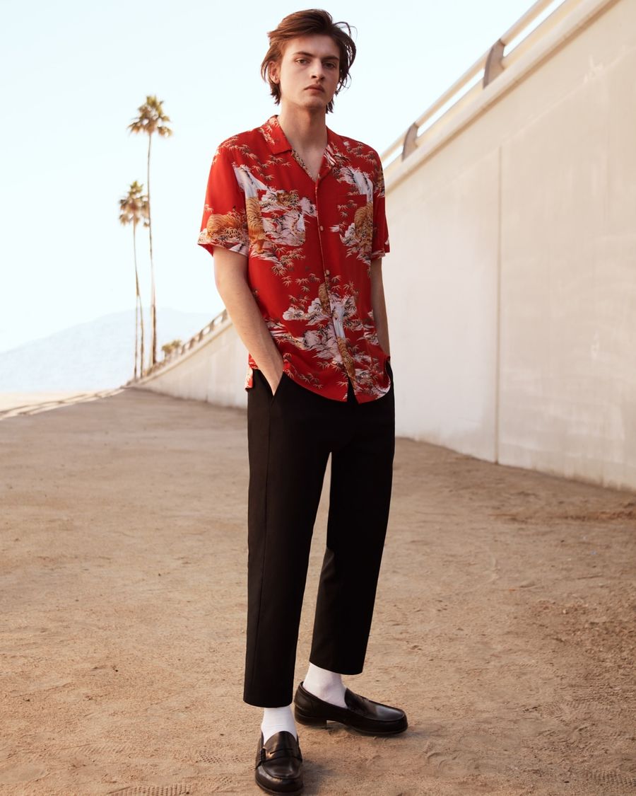 Man wearing a short sleeve red Japanese-inspired printed Hawaiian shirt with black tailored trousers and loafers.
