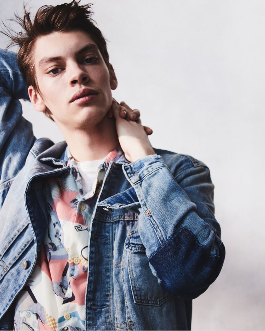 Portrait d'un homme portant une chemise hawaïenne avec une veste en jean et un t-shirt blanc.