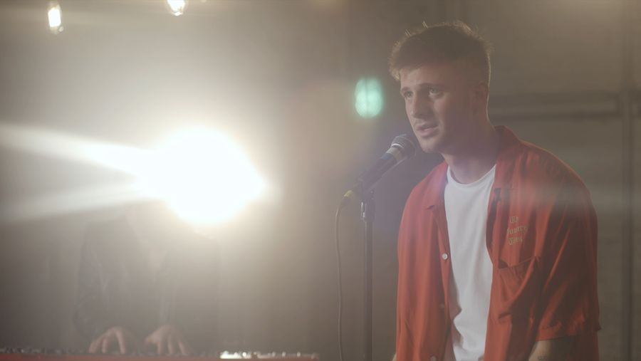Portrait of Quinn Lewis singing during our latest La sessions recording wearing a red shirt from our men's collection.