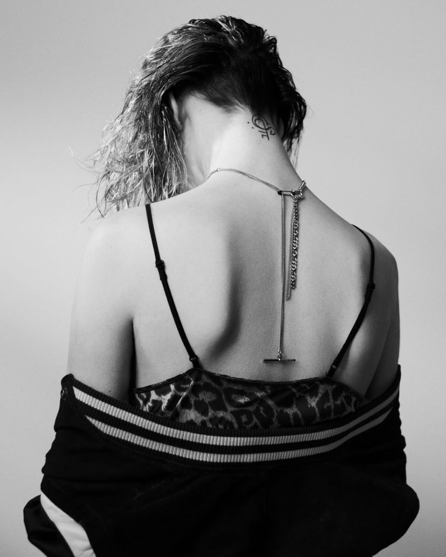 Foto in bianco e nero di una donna con un abito leopardato con spalline trasparenti e una giacca collegiale.