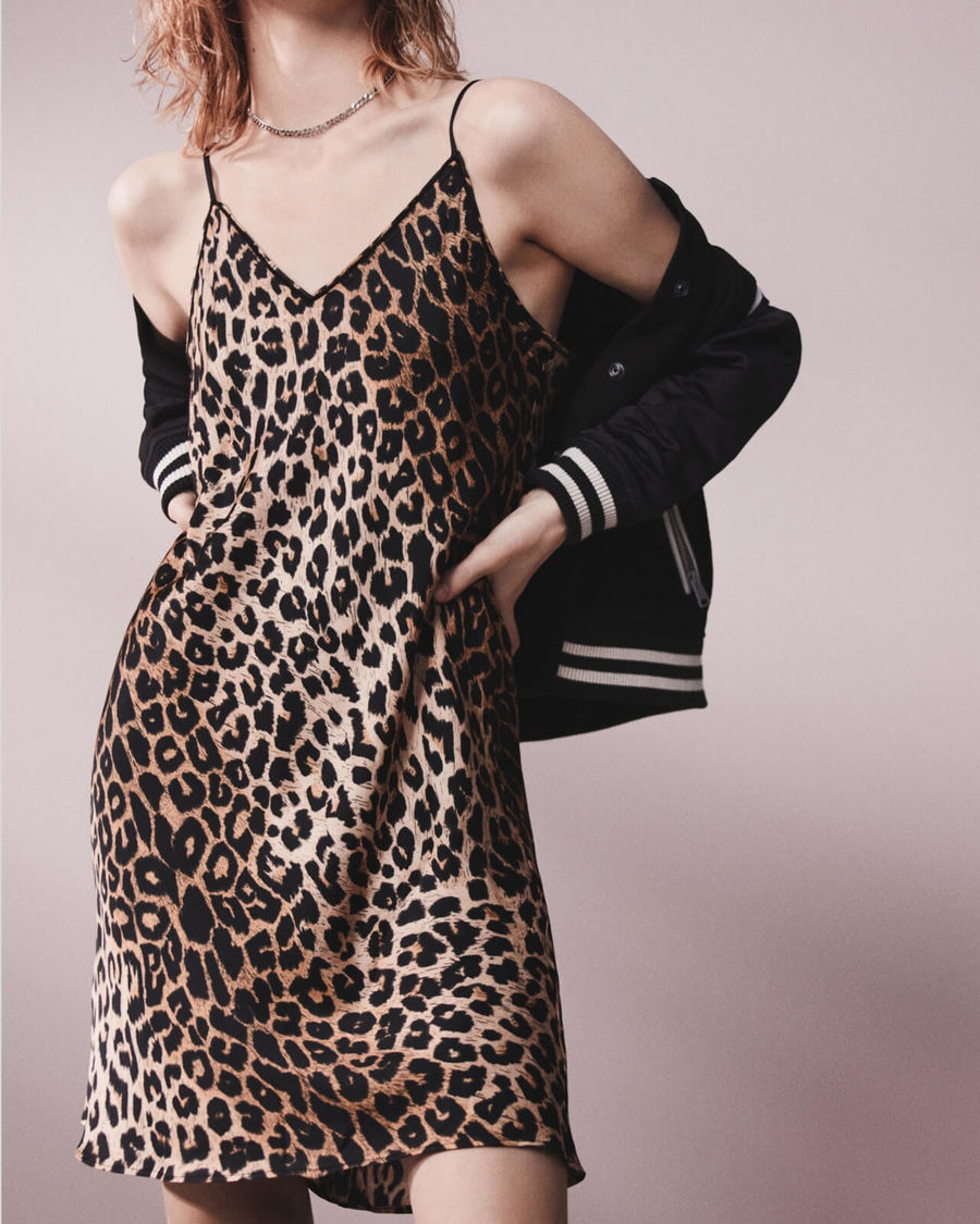 Donna che indossa un abito con spalline sottili a fantasia leopardata con una giacca collegiale.