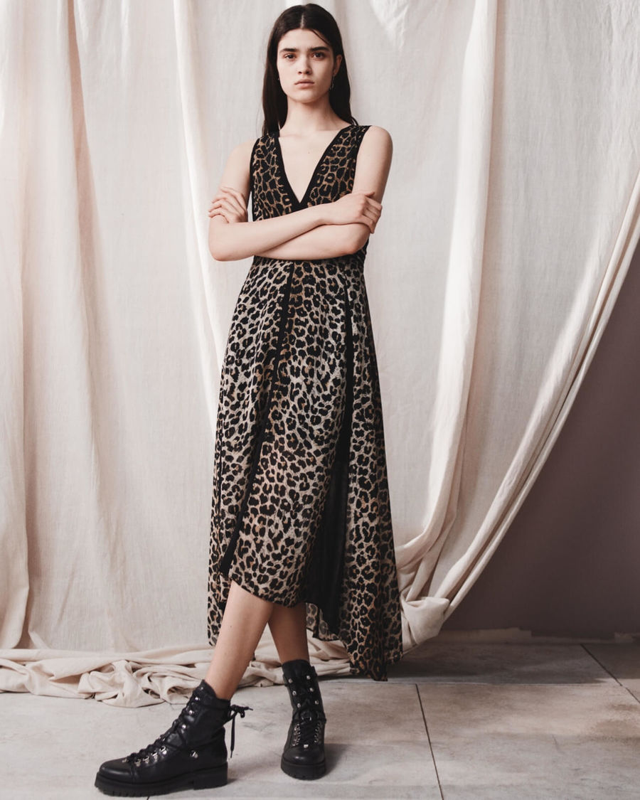Immagine di una donna che indossa un abito leopardato lungo con anfibi in pelle.