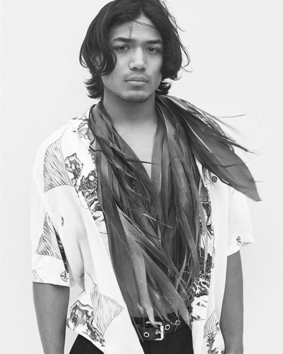 Black and white portrait of a man wearing a printed Hawaiian shirt.