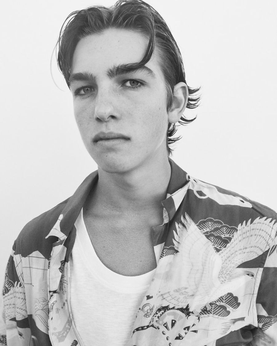 Black and white portrait of a man wearing a printed Hawaiian shirt.